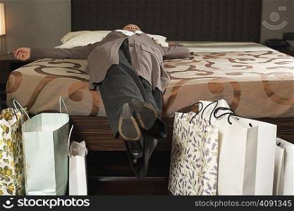 Mature woman on bed with shopping