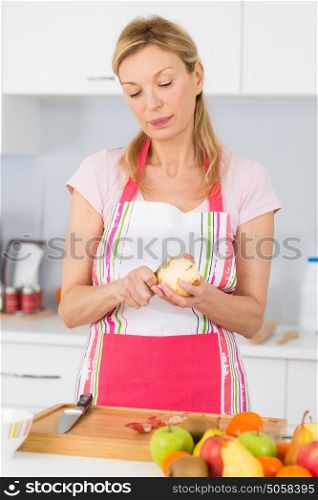 mature woman peeling an apple