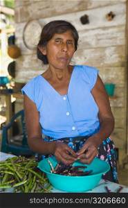 Mature woman peeling beans in a kitchen, Papantla, Veracruz, Mexico