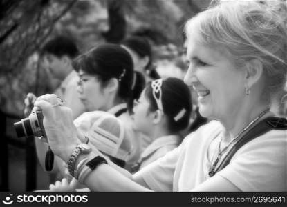 Mature woman photographing a performance