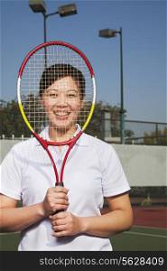 Mature woman playing tennis, portrait