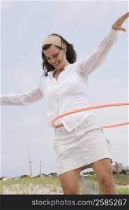 Mature woman playing with a plastic hoop and smiling