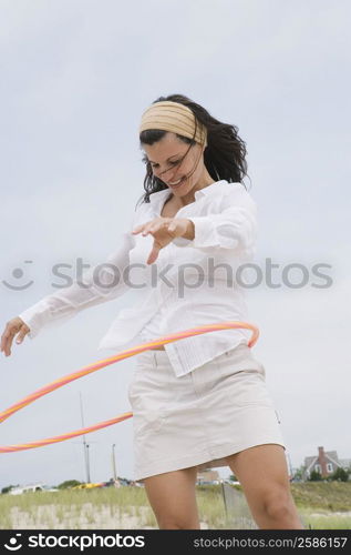 Mature woman playing with a plastic hoop and smiling