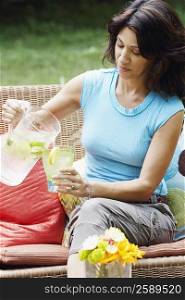 Mature woman pouring lemonade into a glass