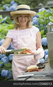 Mature woman preparing food on a barbecue grill and smiling