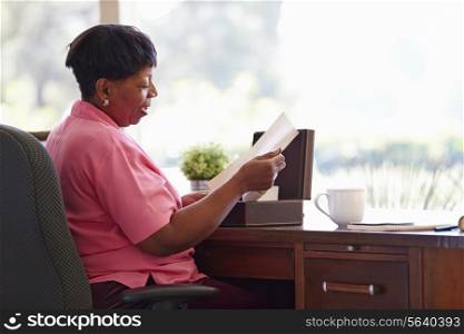 Mature Woman Putting Letter Into Keepsake Box