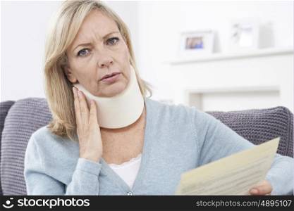 Mature Woman Reading Letter After Receiving Neck Injury