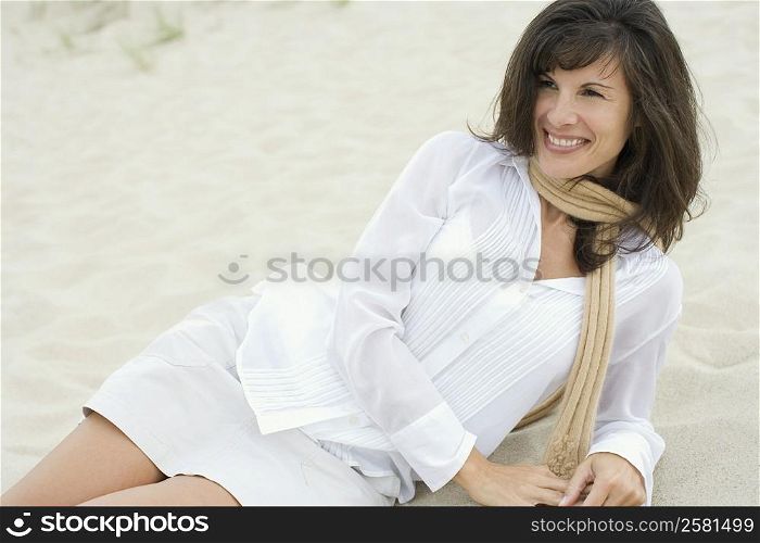 Mature woman reclining in sand on the beach