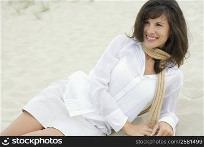 Mature woman reclining in sand on the beach