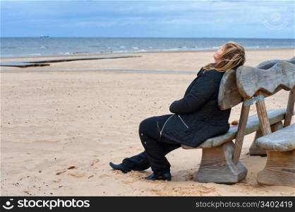 Mature woman relaxing at the Baltic sea in autumn day.
