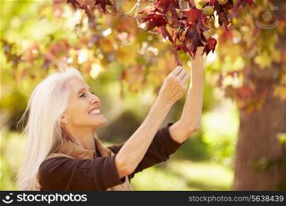 Mature Woman Relaxing In Autumn Landscape