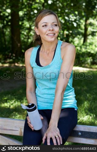 Mature Woman Resting Whilst Exercising In Countryside