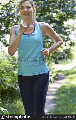 Mature Woman Running Outdoors In Countryside