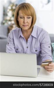Mature woman shopping online at home during Christmas