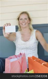 Mature woman showing a credit card and smiling