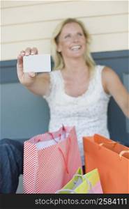 Mature woman showing a credit card and smiling