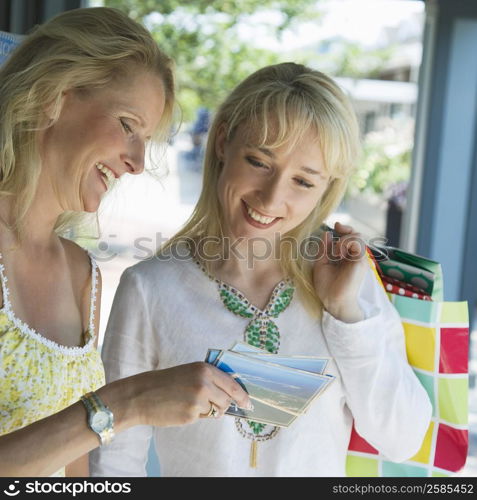 Mature woman showing photograph to a mid adult woman and smiling