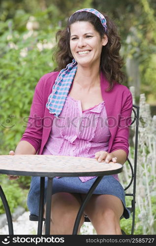 Mature woman sitting at a table and smiling