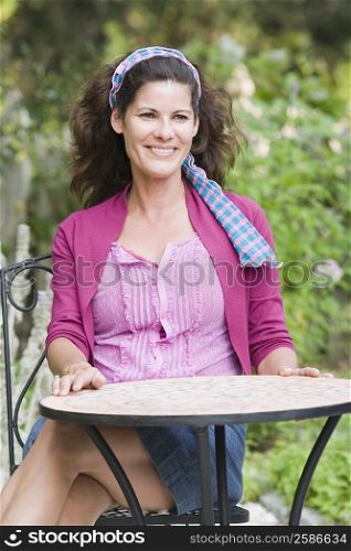 Mature woman sitting at a table and smiling
