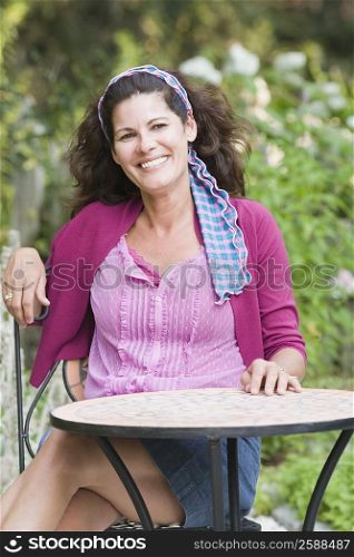 Mature woman sitting at a table and smiling