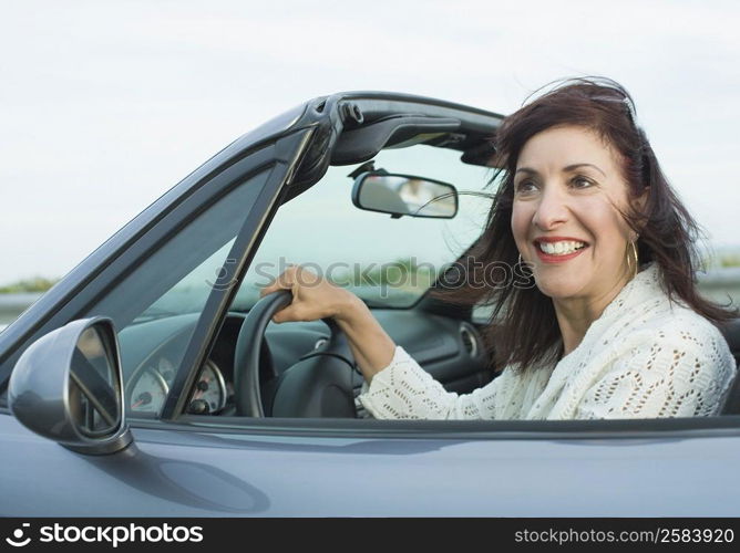 Mature woman sitting in a car and smiling