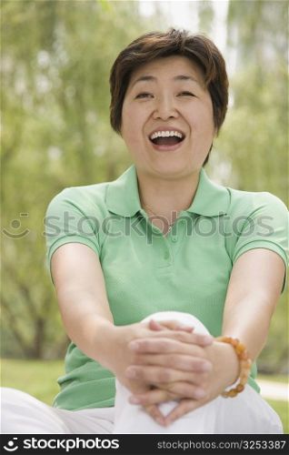 Mature woman sitting in a park and laughing
