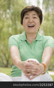 Mature woman sitting in a park and laughing