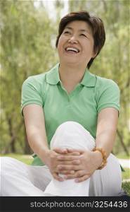 Mature woman sitting in a park and smiling