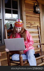 Mature woman sitting on a bench and using a laptop