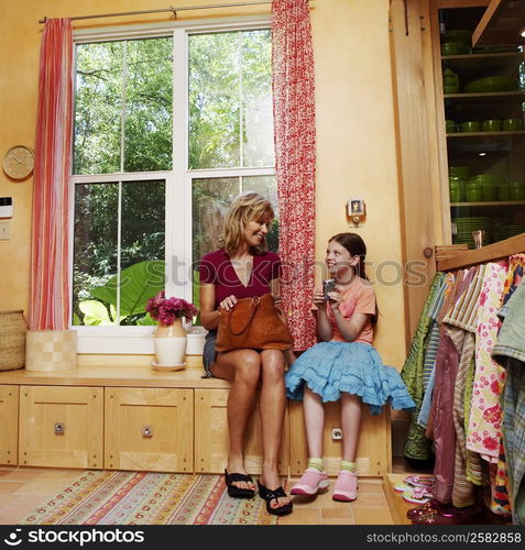 Mature woman sitting on a cabinet with her daughter