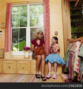 Mature woman sitting on a cabinet with her daughter