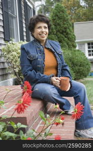 Mature woman sitting on steps and smiling