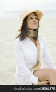 Mature woman sitting on the beach and smirking