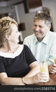 Mature woman sitting with a senior man and smiling