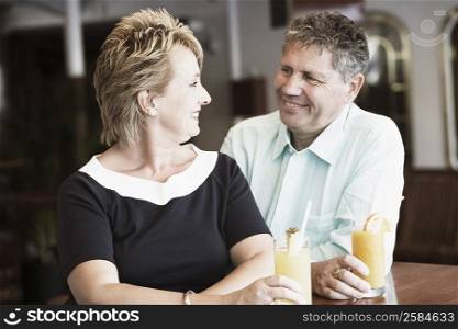 Mature woman sitting with a senior man and smiling