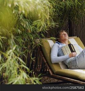 Mature woman sleeping on a lounge chair