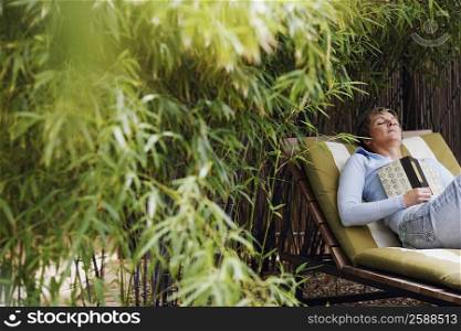 Mature woman sleeping on a lounge chair