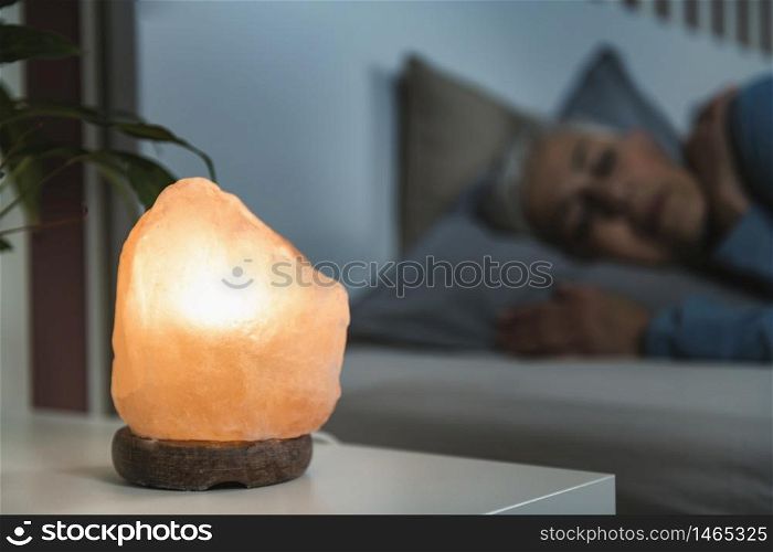 Mature Woman Sleeping with a Himalayan Salt Lamp in Bedroom