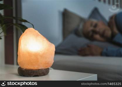 Mature Woman Sleeping with a Himalayan Salt Lamp in Bedroom