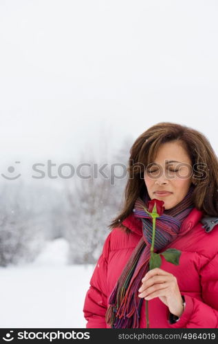 Mature woman smelling a rose