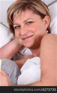 Mature woman smiling in bed