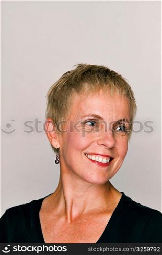 Mature woman smiling while looking away.