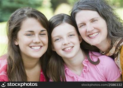 Mature woman smiling with her two daughters
