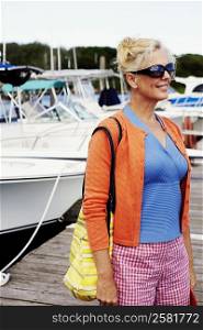 Mature woman standing at a dock and smiling