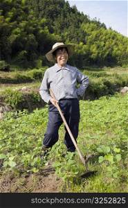 Mature woman standing in a field and smiling, Emerald Valley, Huangshan, Anhui Province, China