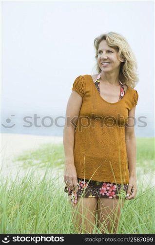 Mature woman standing in a grassy field and smiling