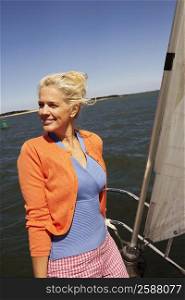 Mature woman standing in a sailboat and smiling