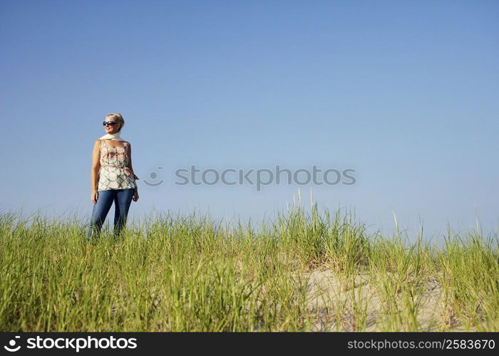 Mature woman standing on the beach and smiling