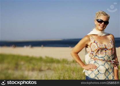 Mature woman standing on the beach and smiling