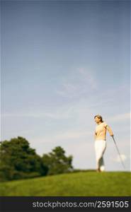 Mature woman standing with a golf club